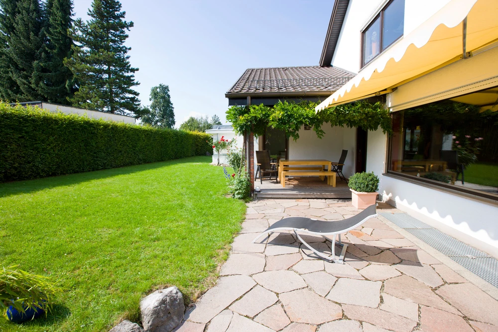Terrasse en pierre naturelle avec jardin verdoyant